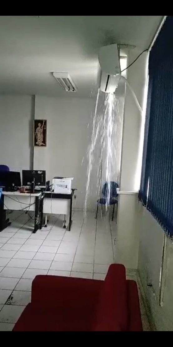 Água caindo pelo ar-condicionado na sala.