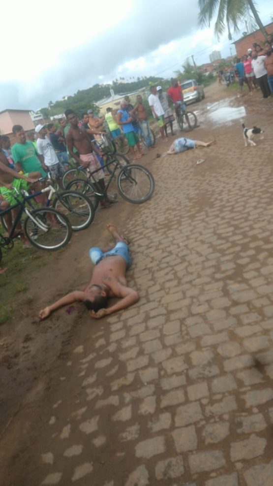 Homens no solo baleados.